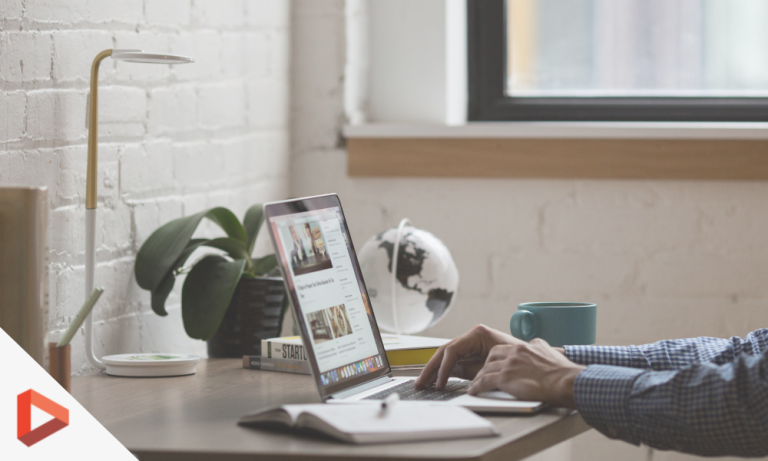 Ordinateur portable et smartphone sur un bureau près d'une fenêtre
